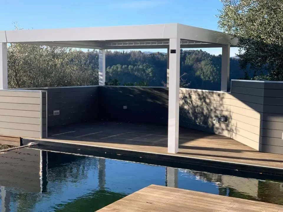 Pergola bioclimatica installata accanto a una piscina