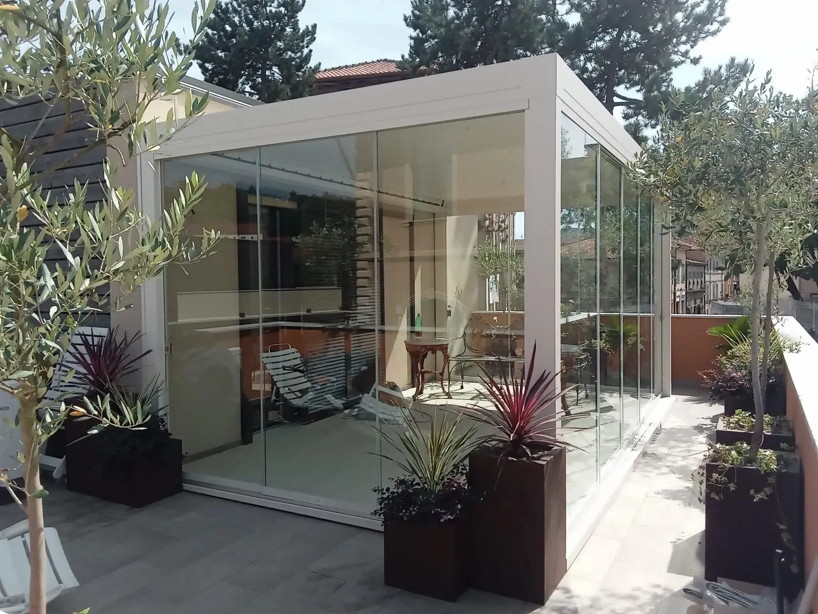 Pergola bianca con chiusure vetrate in giardino