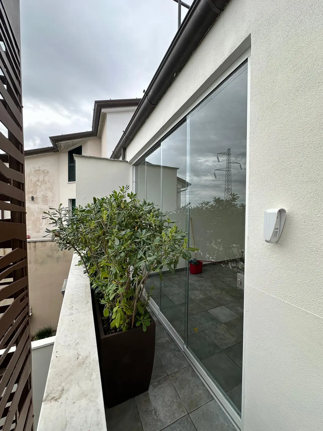 Chiusura vetrata laterale installata su un terrazzo