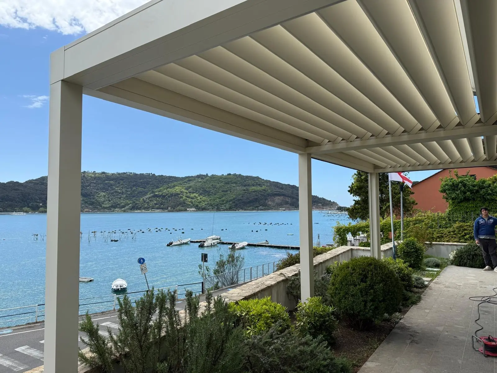 Pergola bioclimatica bianca in un giardino sul mare