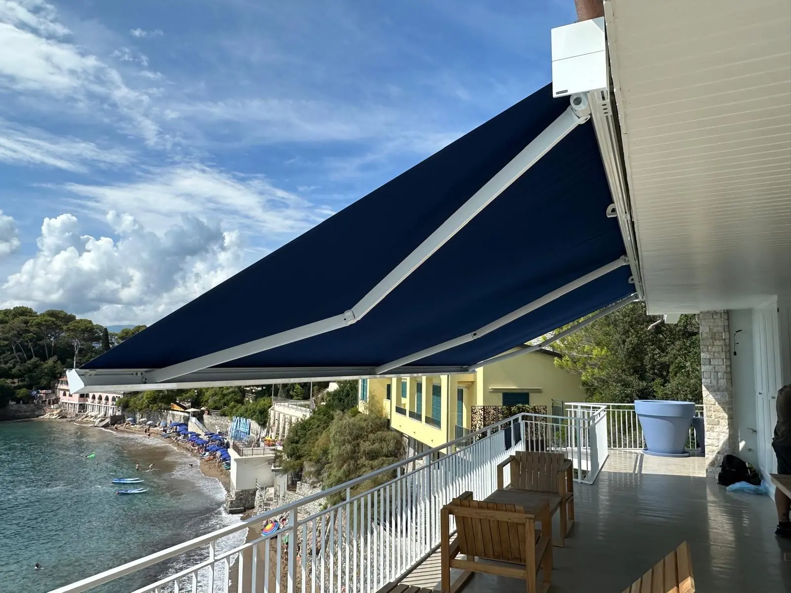 Tenda da sole blu installata su una terrazza sul mare